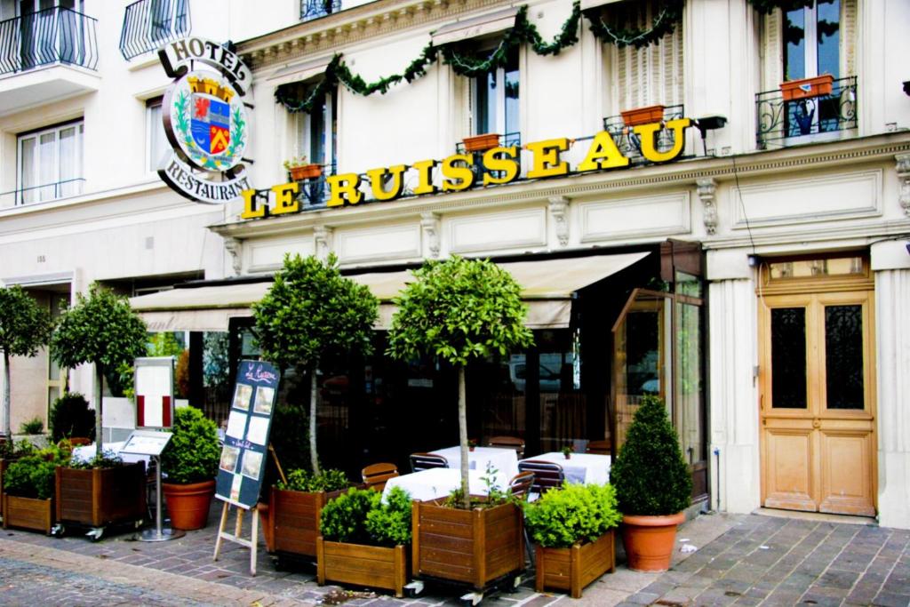 a restaurant with a sign on the side of a building at Le Ruisseau in Saint-Mandé