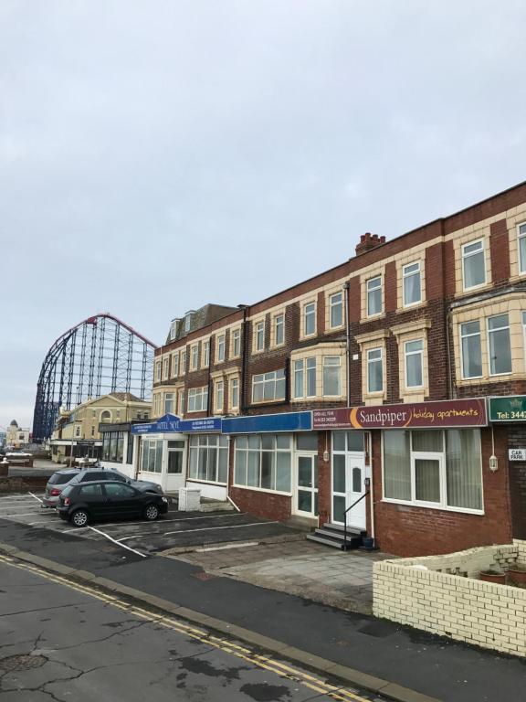 un aparcamiento vacío frente a un edificio en Sandpiper Holiday Apartments, en Blackpool