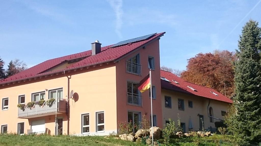 un edificio con una bandera a un lado. en FeWo/GZ Hannelore Müller, en Leienfels