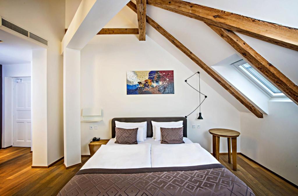 a bedroom with a large bed in a attic at Hotel Golden Crown in Prague