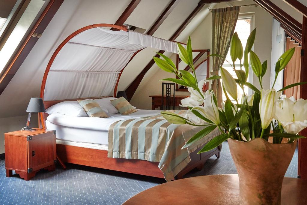 a bedroom with a bed and a table with a plant at Rezydencja Solei Old Town in Poznań