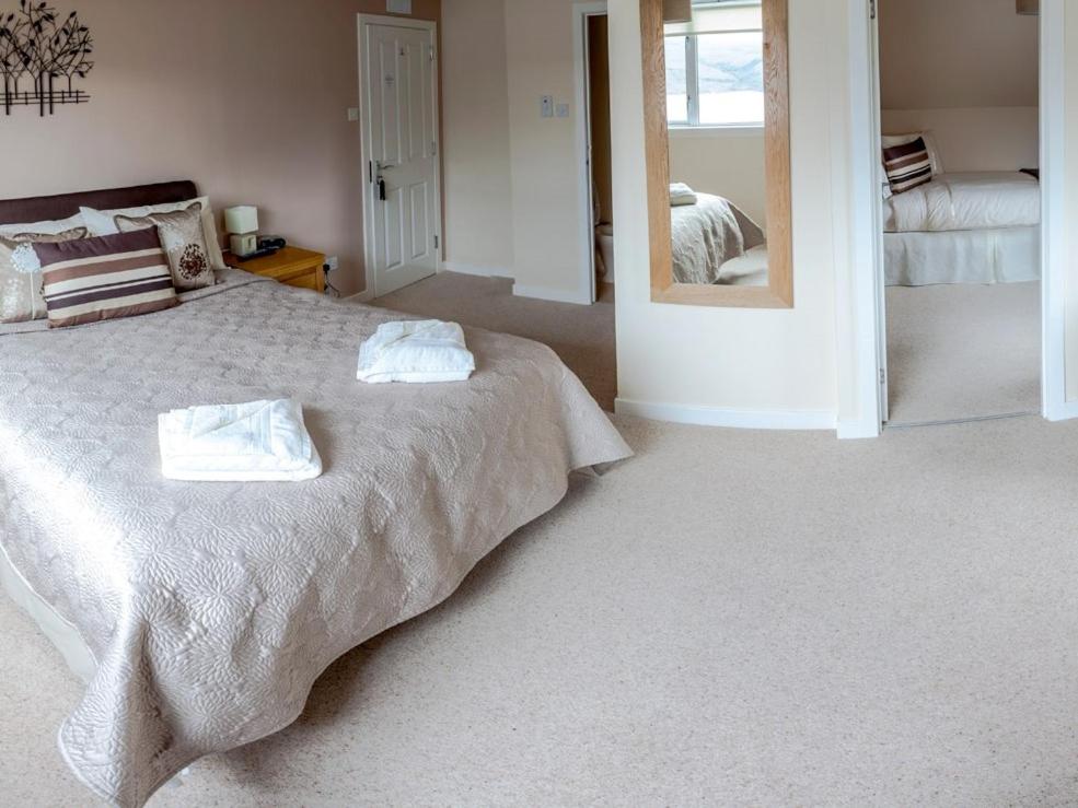 a bedroom with a bed with two towels on it at Ardlair Guest House in Ullapool