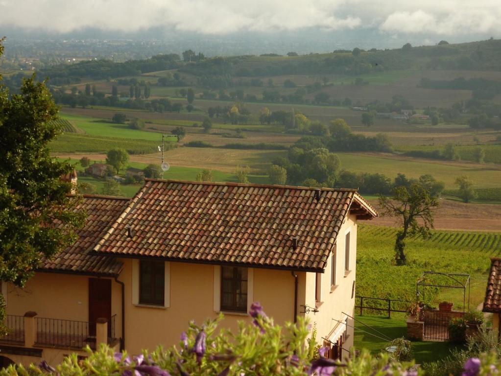 a house with a tiled roof and a field at Genius Loci Country Inn in Bevagna