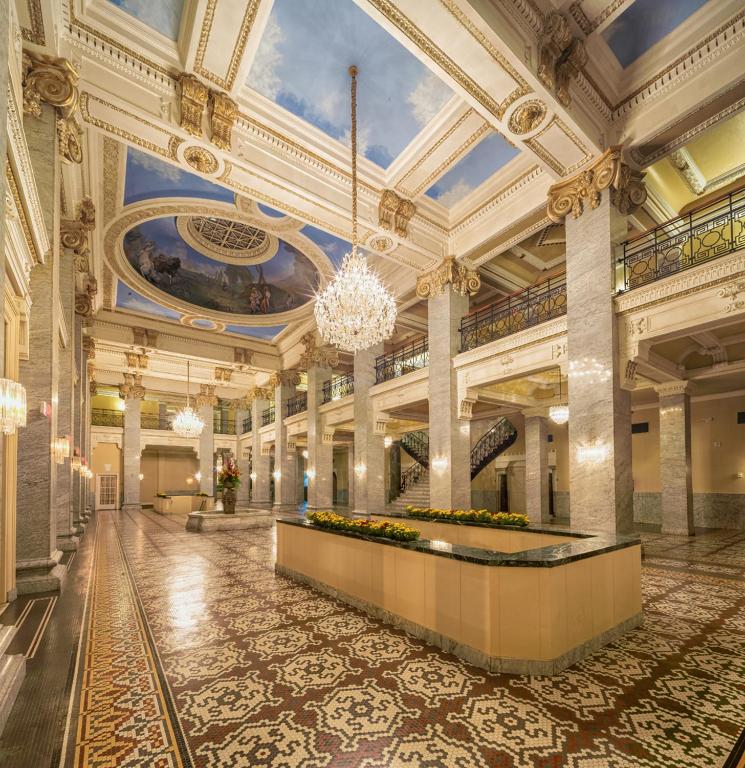 Un gran vestíbulo con una lámpara de araña en un edificio. en Hotel Bentley, en Alexandria