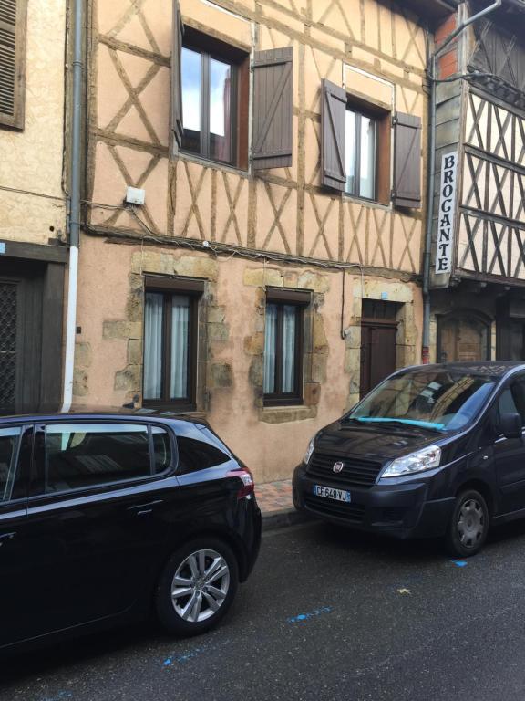 two cars parked in front of a building at Chambres à Nogaro in Nogaro