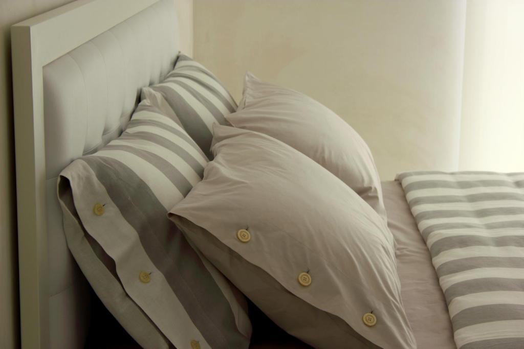 einen Haufen Kissen auf einem Bett in einem Zimmer in der Unterkunft Home BB Milano in Mailand