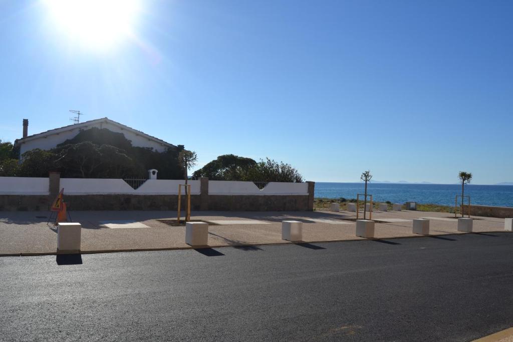 a road with a building and the ocean in the background at B&B Miramare in Platamona