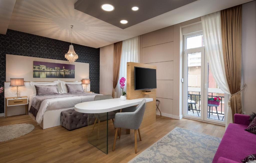 a bedroom with a bed and a table and a tv at VIP Rooms in Split