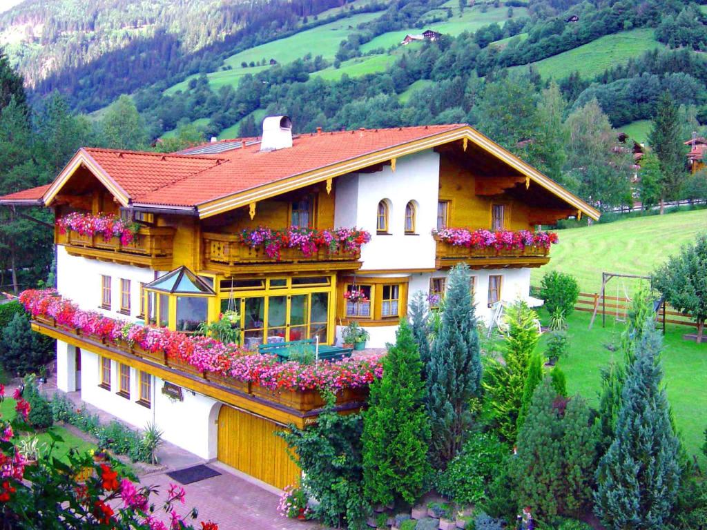 a house with flowers on the side of it at Gästehaus ALPINA in Dorfgastein