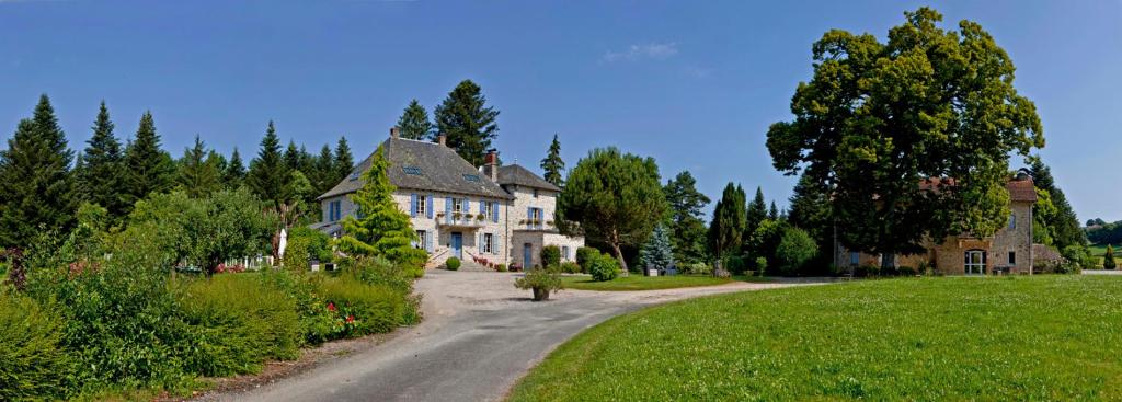 ein großes Haus auf einer Straße auf einem Feld in der Unterkunft Les Maisons de Concasty in Boisset