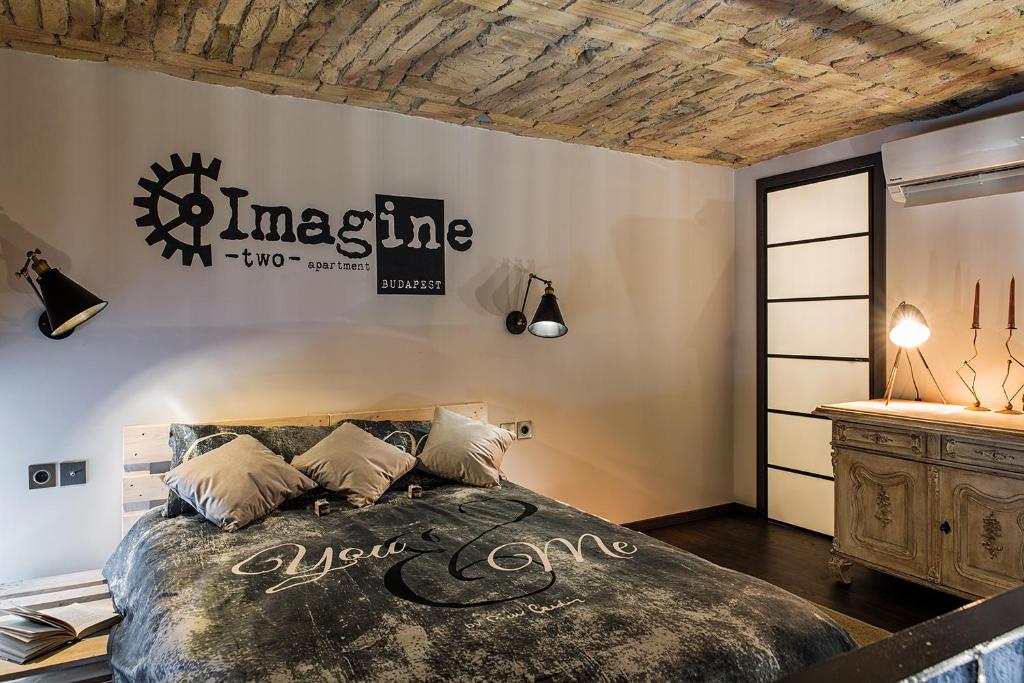 Hotel Imagine Budapest Loft Apartments, a bedroom with a bed and a sign on the wall at Imagine Budapest Loft Apartments in Budapest