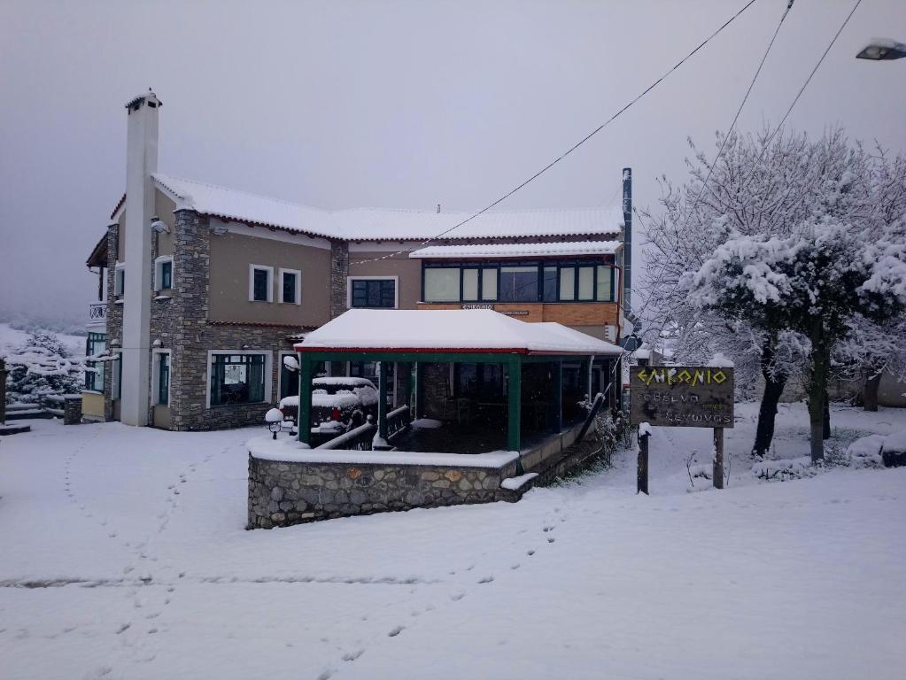 une maison avec une véranda couverte de neige devant elle dans l'établissement Elikonio, à Agia Anna
