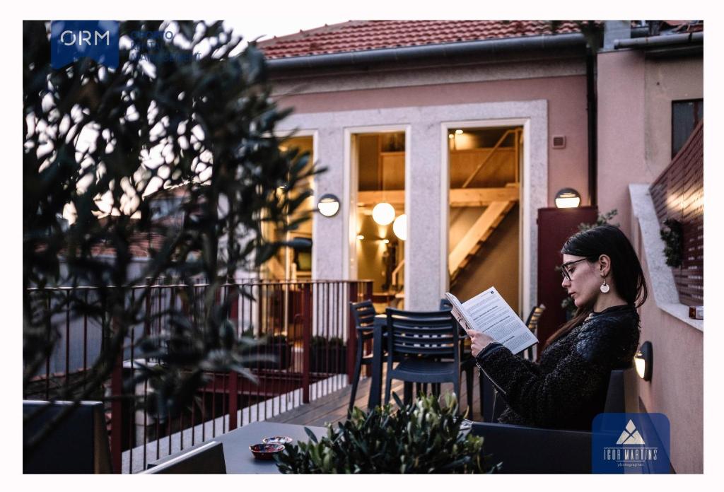 ポルトにあるORM - Almada Terrace Apartmentの中庭で本を読む女