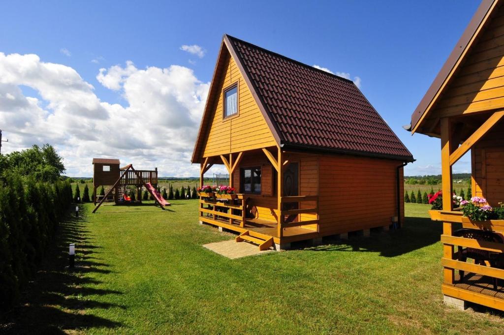 een klein huis met een speeltuin in een veld bij Domki Nadia in Jezierzany