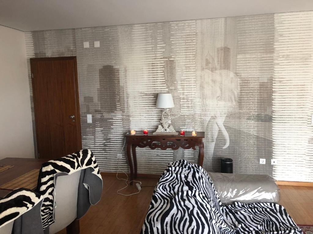 a living room with a zebra print couch and a table at Sea and Marina view Apartment in Setúbal