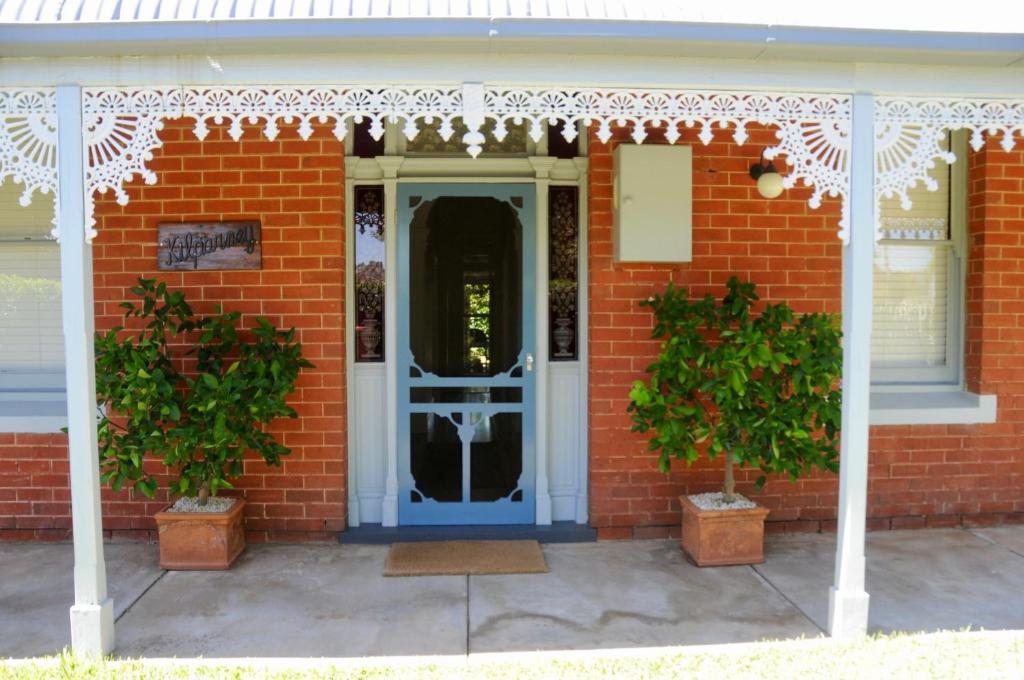 a red brick house with a blue door at Kilparney House in Benalla