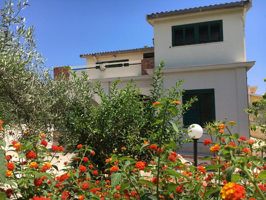 un edificio con un montón de flores delante de él en Villa del Falso Pepe, en Avola