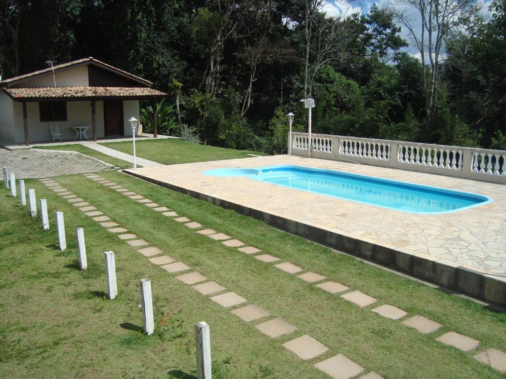 a swimming pool in a yard next to a house at Chácara em Serra Negra in Serra Negra