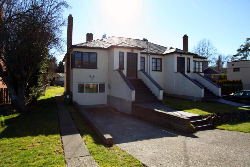 uma casa branca com escadas num quintal em Central Avenue in the Heart of Oak Bay 26 em Victoria