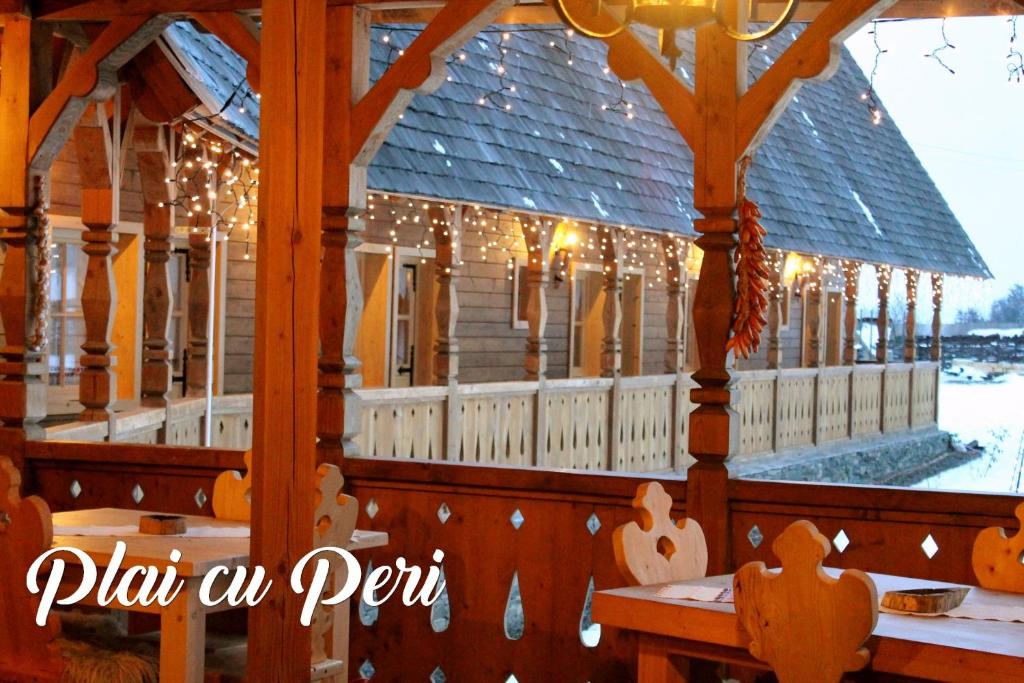 a house covered in christmas lights and a table at "Plai cu Peri" in Săpânța