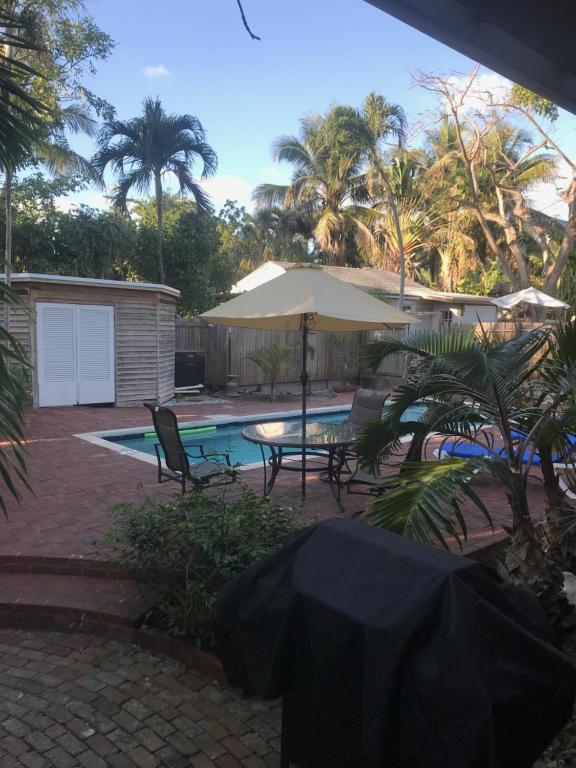 patio con tavolo, ombrellone e piscina di New Orleans House - Gay Male Adult Guesthouse a Key West