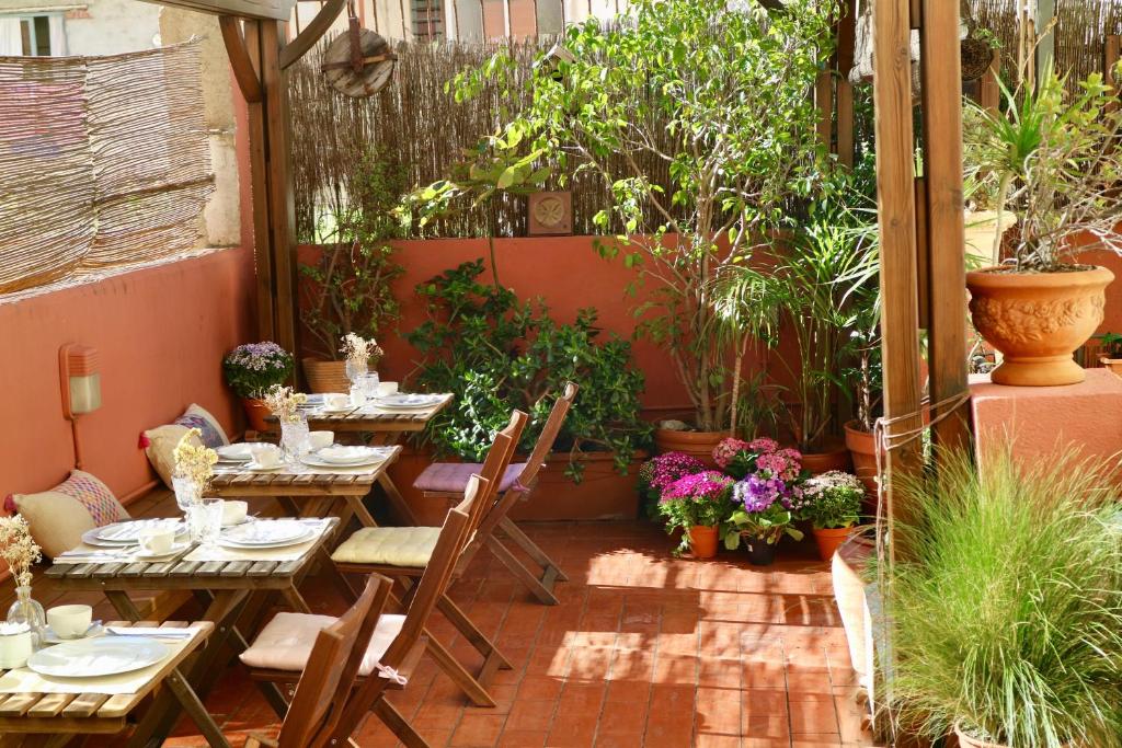 un patio con tavoli, sedie e piante di Hostal Poblenou a Barcellona