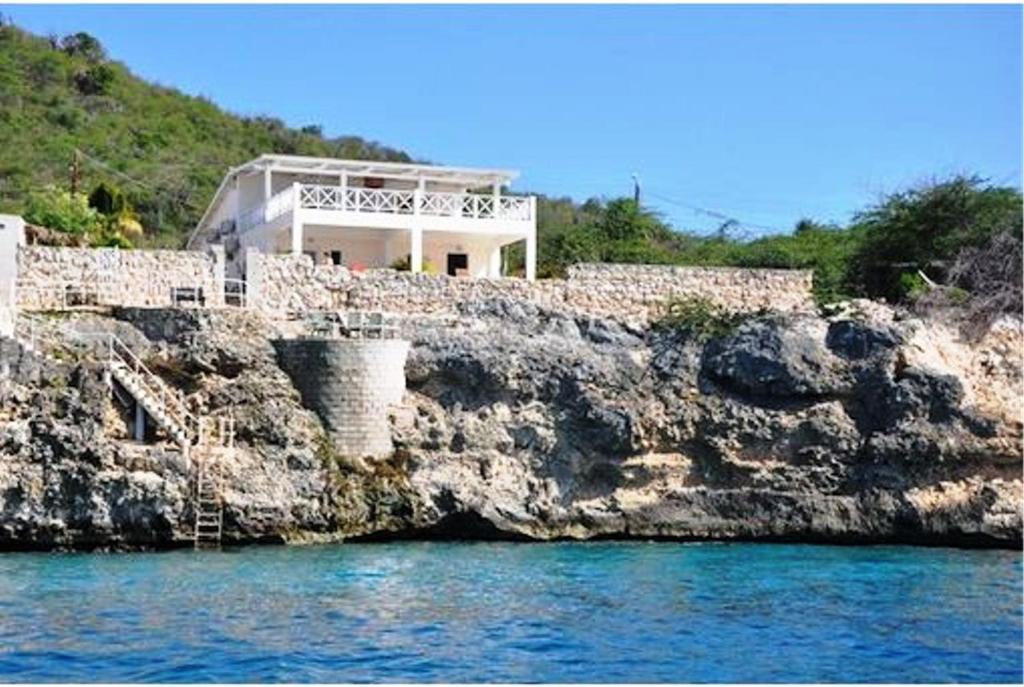 ein Haus an der Seite einer felsigen Klippe in der Unterkunft Dolphin Hearthouse in Lagun