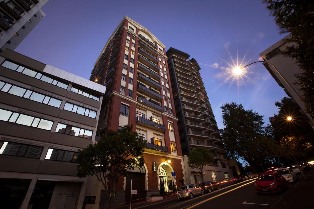 a tall building on a city street at night at Quest on Eden Serviced Apartments in Auckland