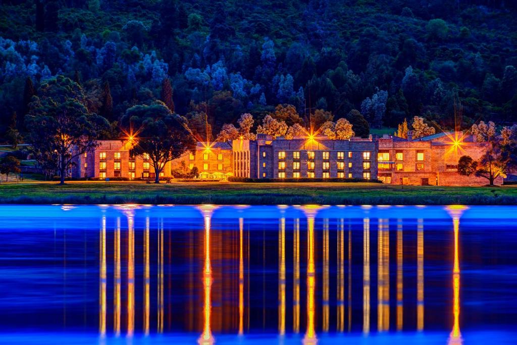 - un grand bâtiment à côté d'un lac la nuit dans l'établissement Estelar Paipa Hotel Spa & Y Centro De Convenciones, à Paipa