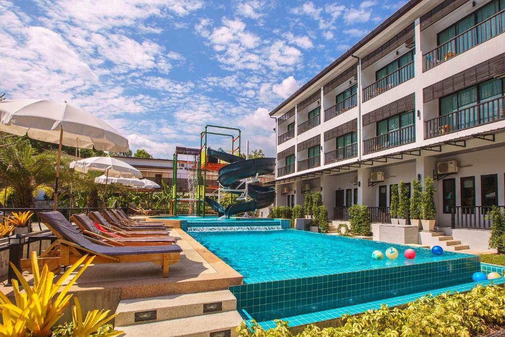 a pool at a hotel with chairs and a slide at Aonang Viva Resort - SHA Plus in Ao Nang Beach