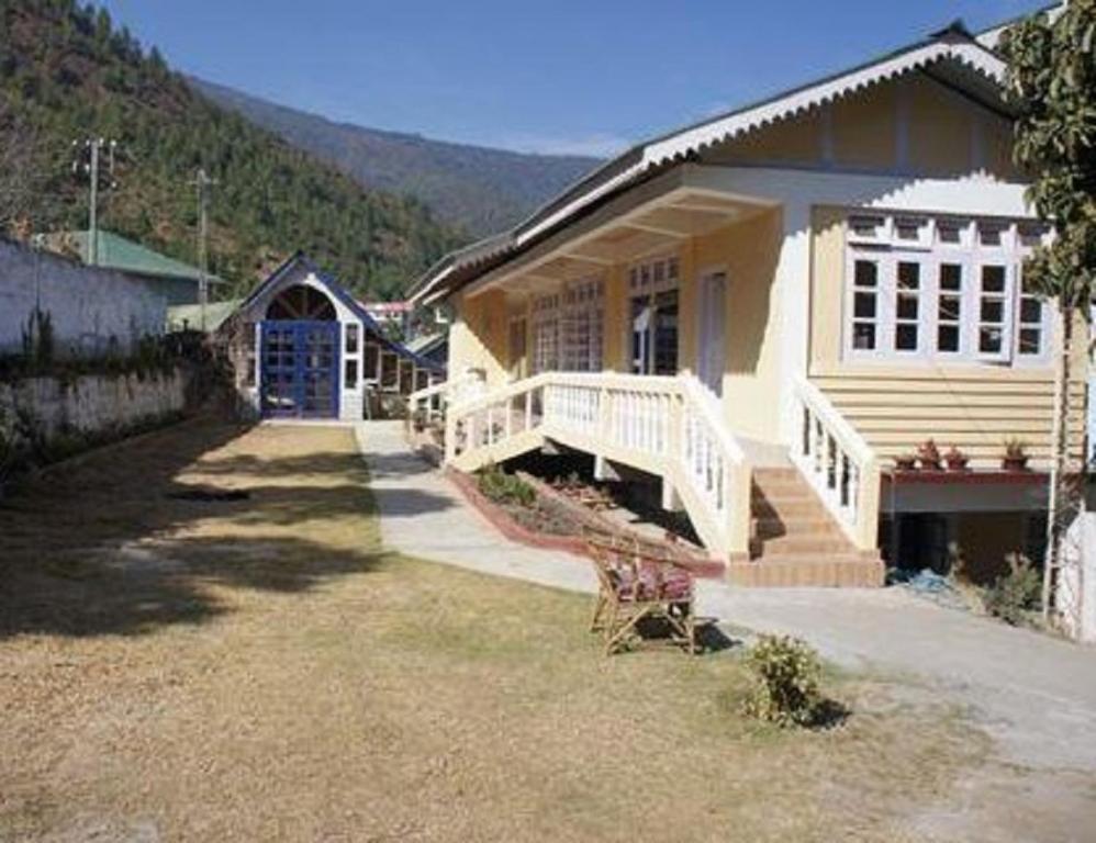 uma pequena casa com um alpendre e escadas para ela em Pemaling Lords Inn Dirang em Dirang Dzong