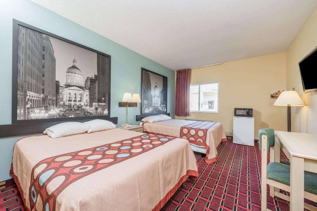 a hotel room with two beds and a desk at Super 8 by Wyndham Martinsville in Martinsville