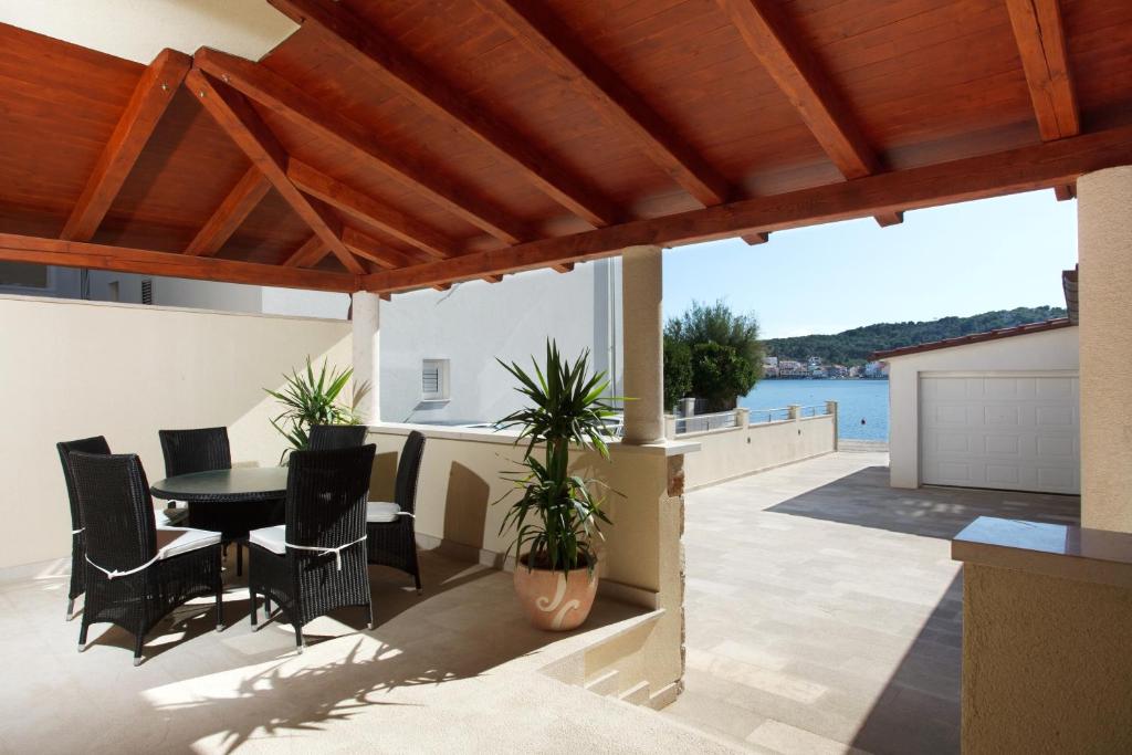a patio with a table and chairs and a view of the water at Apartments Tisno - Villa Mare in Tisno