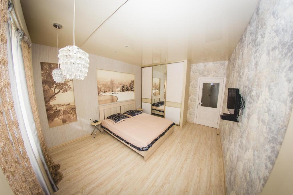 a bedroom with a bed and a chandelier at ATLANT Apartments 109 in Voronezh