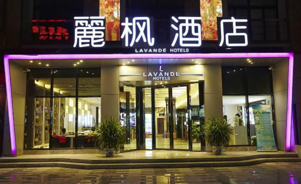 een verlichte winkel voor een gebouw 's nachts bij Lavande Hotel Zhuhai Gongbei Port Square in Zhuhai