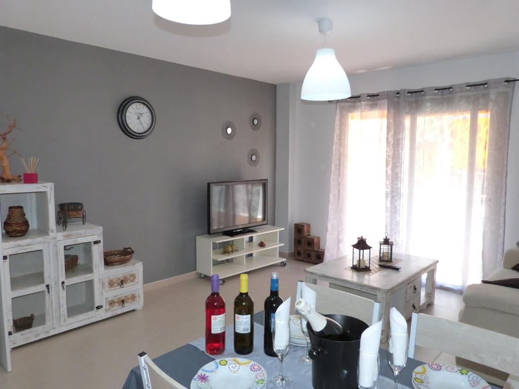 salon ze stołem i butelkami wina w obiekcie Alcalà Center A 5 minutos del paseo y playas w mieście Alcalá