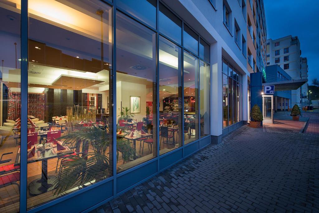 restauracja ze stołami i krzesłami w oknach budynku w obiekcie Rezidence Emmy w Pradze