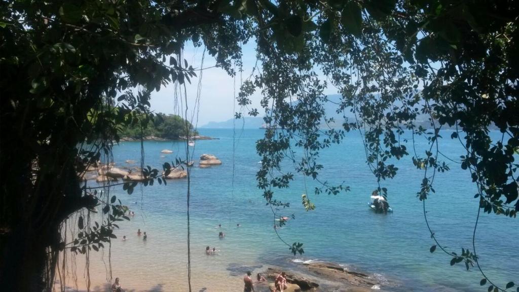 una vista di una spiaggia con persone in acqua di Casa Aconchegante ao Pé da Praia do Portinho a Ilhabela