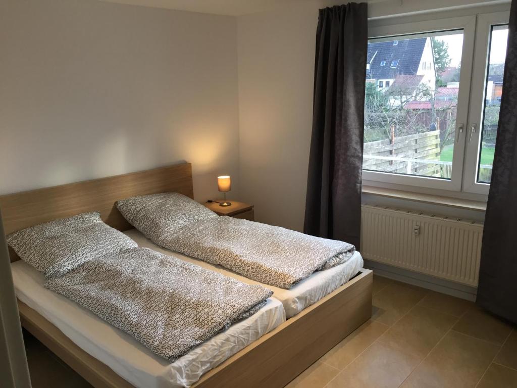 uma cama com duas almofadas ao lado de uma janela em BS Living Ap am Zoo em Braunschweig