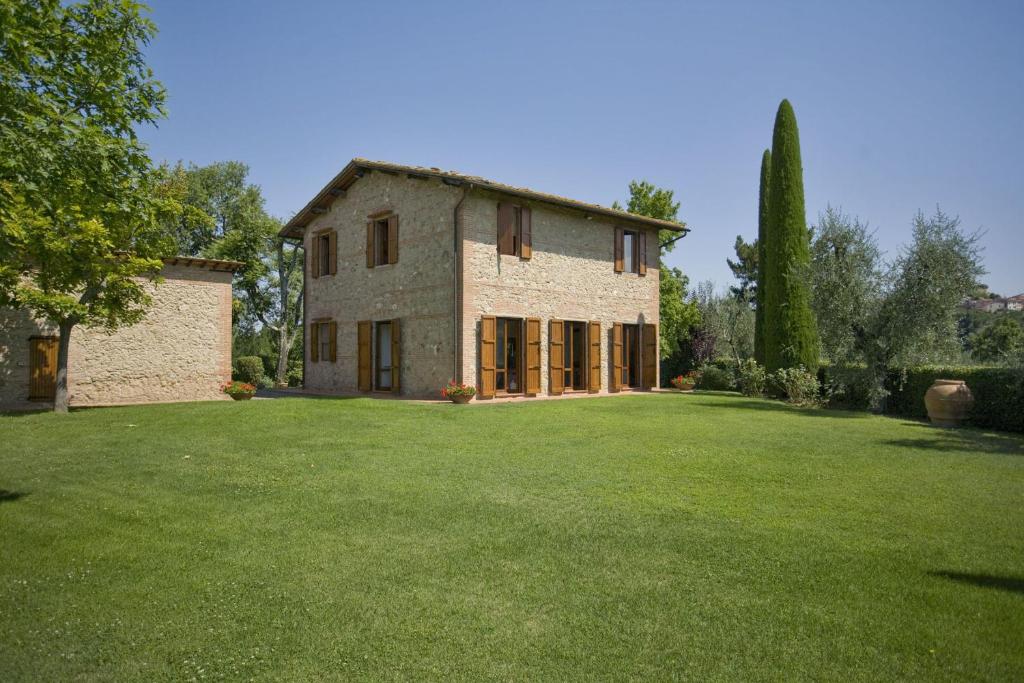 a large stone house with a large yard at La Fonte by Salogi Villas in Palaia