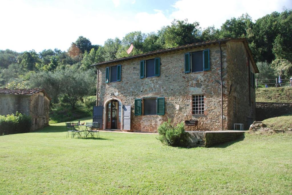 an old stone house with a table in a yard at Villa Magrini in San Gennaro