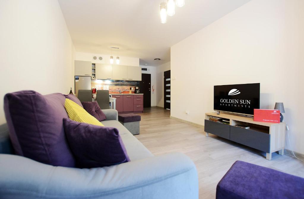 a living room with a couch and a tv at Apartament Polanki Park-kryty basen in Kołobrzeg