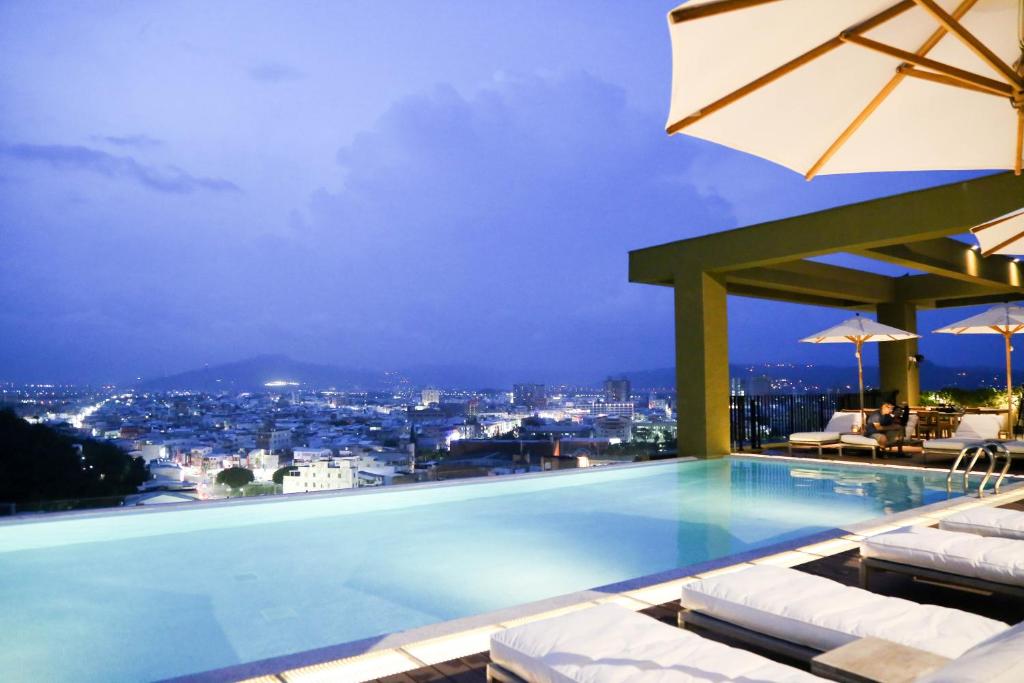 a swimming pool with a view of a city at night at The Gaya Hotel in Taitung City