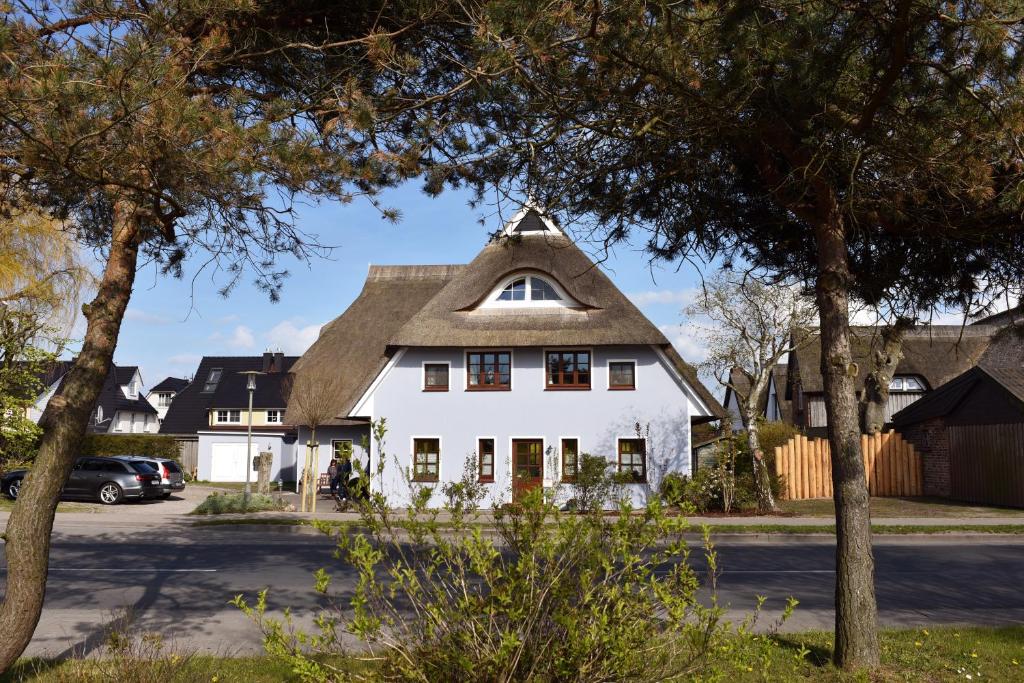 a white house with a thatched roof at Landhaus Esperort in Ahrenshoop