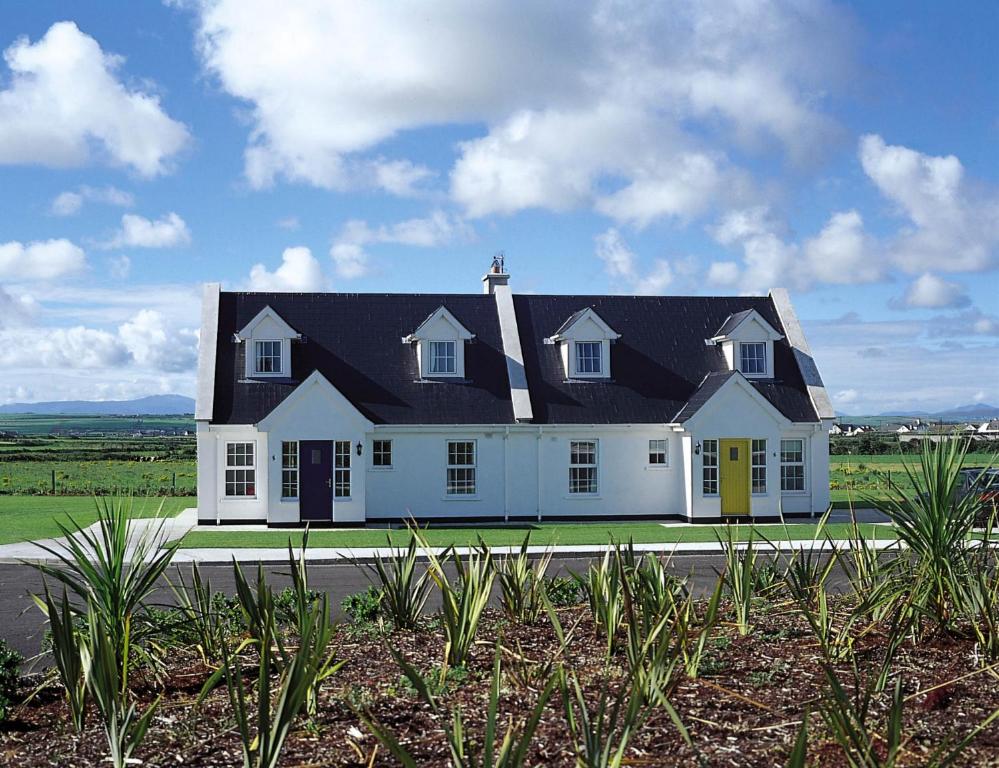una gran casa blanca con techo negro en Ballybunion Holiday Cottages, en Ballybunion
