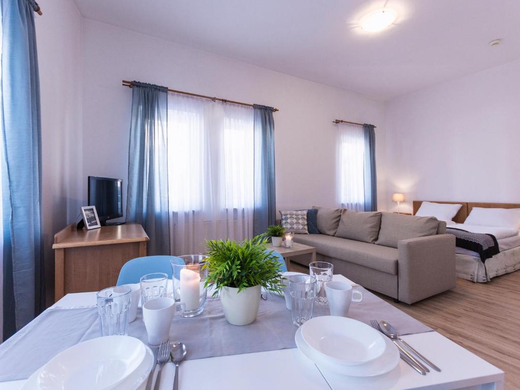 a living room with a table and a couch at VacationClub - Olymp Apartment 503 in Kołobrzeg
