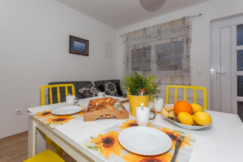 una mesa de comedor con platos y fruta. en Apartment Dome, en Biograd na Moru