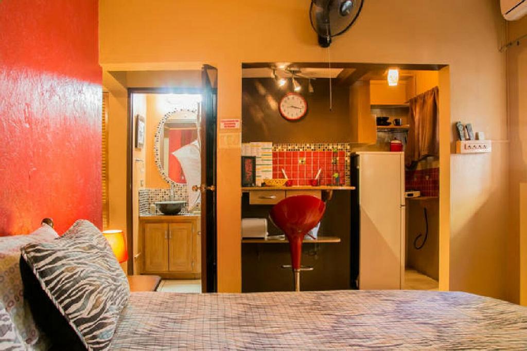uma cozinha com um frigorífico e uma parede vermelha em One32 Guesthouse Red Velvet em Kingston