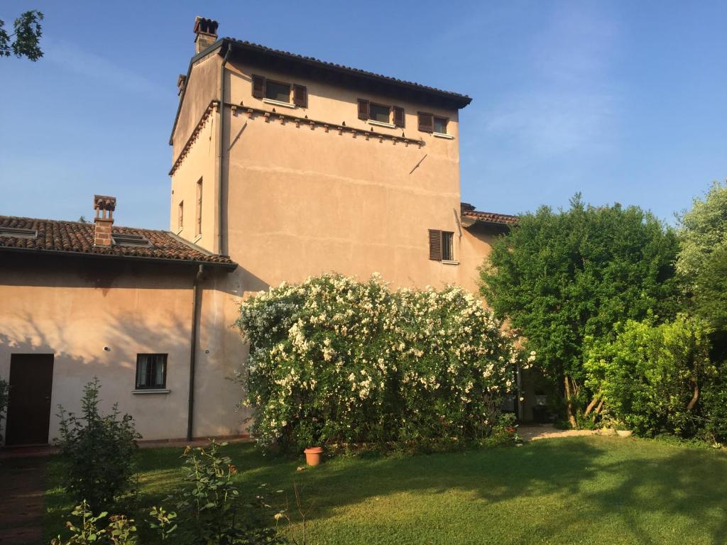 a building with a tree in front of a yard at Dimora Altana in Brescia