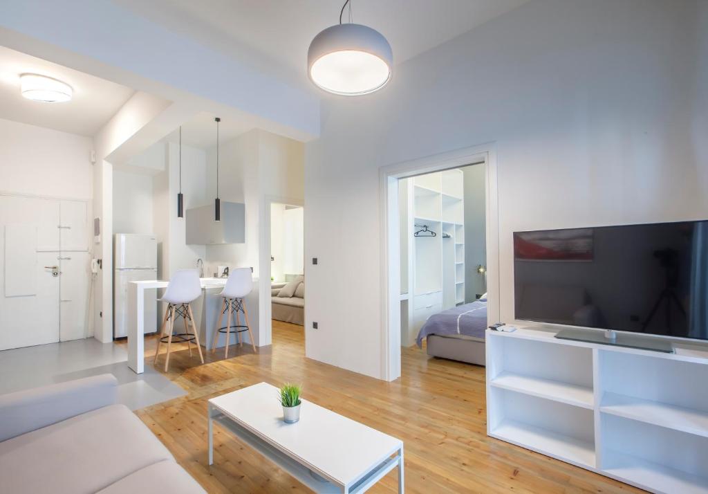 Biały salon z kanapą i telewizorem w obiekcie Thessaloniki Center Apartments w Salonikach